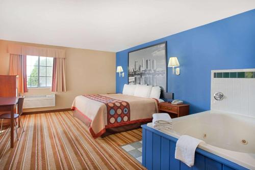 a hotel room with a bed and a bath tub at Super 8 by Wyndham Defiance in Defiance