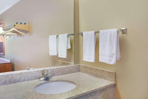 a bathroom with a sink and a mirror and towels at Super 8 by Wyndham Defiance in Defiance
