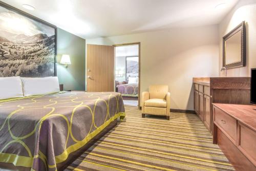 a hotel room with a bed and a chair at Super 8 by Wyndham Buena Vista in Buena Vista
