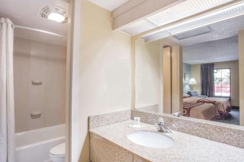 a bathroom with a sink and a mirror at Super 8 by Wyndham Camp Springs/Andrews AFB DC Area in Camp Springs