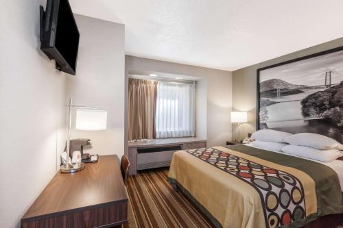 a small hotel room with a bed and a television at Super 8 by Wyndham Schenectady/Albany Area in Schenectady