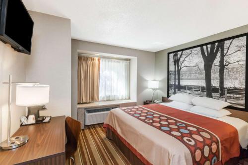 um quarto de hotel com uma cama grande e uma janela em Super 8 by Wyndham Schenectady/Albany Area em Schenectady