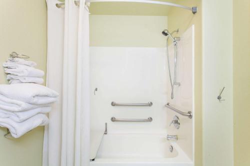 La salle de bains est pourvue d'une douche, d'une baignoire et de serviettes. dans l'établissement Super 8 by Wyndham McCall, à McCall