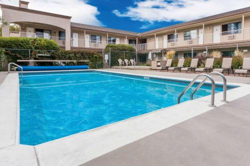 a swimming pool in front of a building at Super 8 by Wyndham Kelowna BC in Kelowna