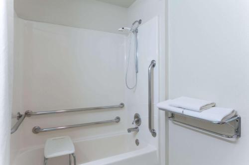 a bathroom with a shower with two towels and a sink at Super 8 by Wyndham Green River in Green River