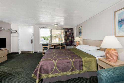 ウェスト・ヤーマスにあるRelax Inn Cape Cod West Yarmouth Hyannisの大きなベッドと机があるホテルの部屋
