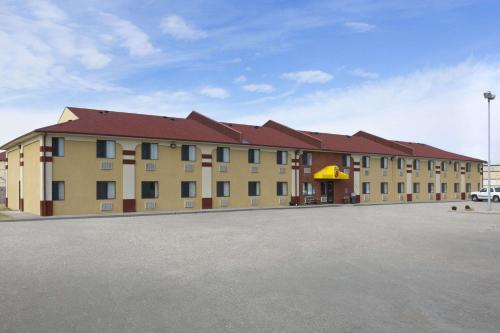 a large tan building with a red roof at Super 8 by Wyndham Park City/North Wichita Area in Park City
