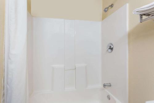 y baño con ducha blanca y cortina de ducha. en Super 8 by Wyndham Piedmont Greenville Area, en Piedmont