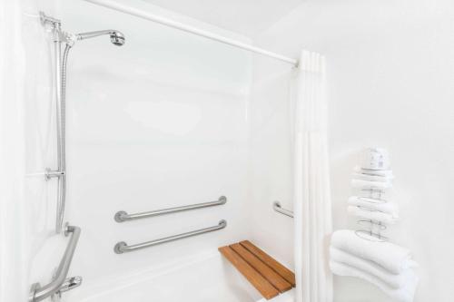 a white bathroom with a shower and towels at West Point Inn & Suites in West Point