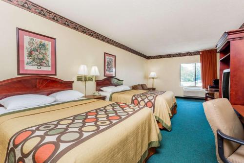 a hotel room with two beds and a television at Super 8 by Wyndham Piedmont Greenville Area in Piedmont