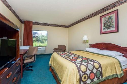 PiedmontにあるSuper 8 by Wyndham Piedmont Greenville Areaのベッドと薄型テレビがあるホテルの部屋