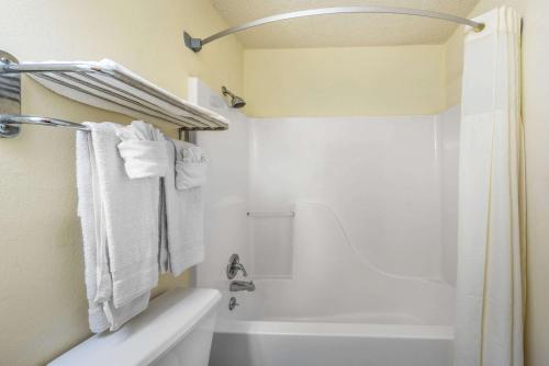 a bathroom with a white tub and a shower with towels at Super 8 by Wyndham Denton in Denton