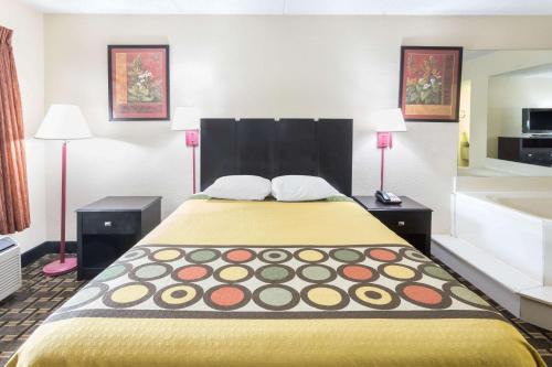 a large bed in a hotel room with two lamps at Super 8 by Wyndham Lithonia in Decatur