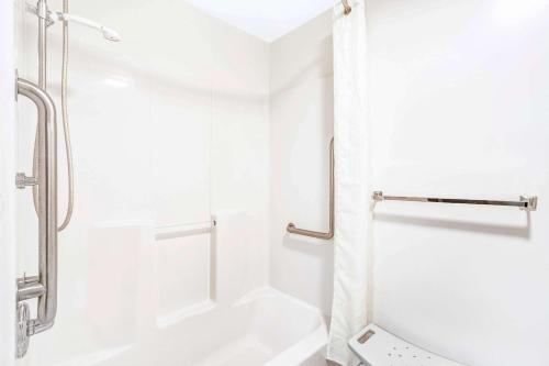 a white bathroom with a shower and a tub at Super 8 by Wyndham McHenry Fox Lake Area in McHenry