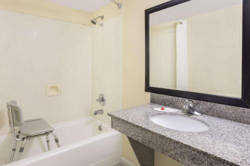 a bathroom with a sink and a mirror and a bath tub at Super 8 by Wyndham Lithonia in Decatur
