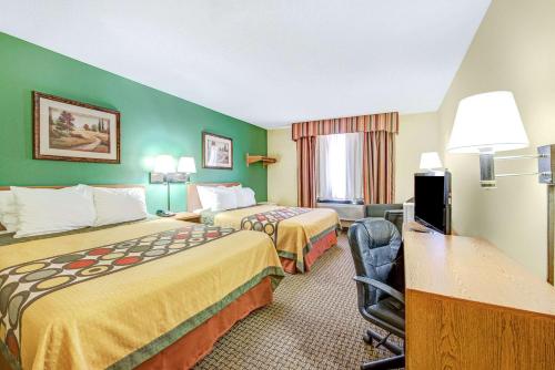 a hotel room with two beds and a desk at Super 8 by Wyndham McKinney/Plano Area in McKinney