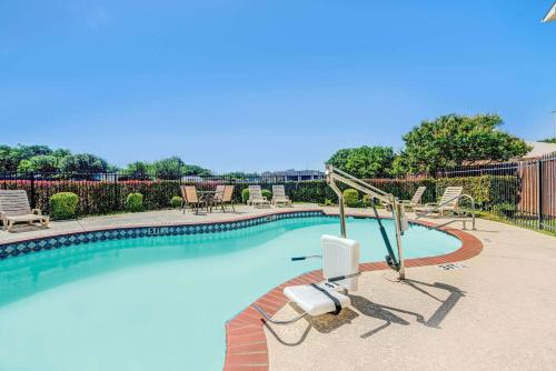 a swimming pool with two lounge chairs and a slide at Super 8 by Wyndham McKinney/Plano Area in McKinney
