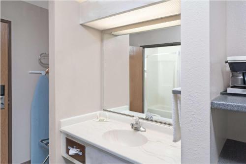 W łazience znajduje się umywalka i lustro. w obiekcie Super 8 by Wyndham Chicago O'Hare Airport w mieście Elk Grove Village