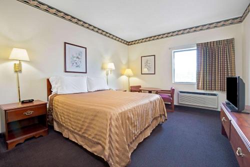 Кровать или кровати в номере Travelodge by Wyndham St. Louis