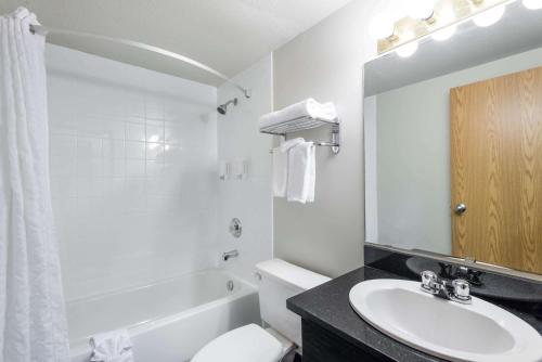 a bathroom with a sink and a toilet and a mirror at Super 8 by Wyndham Grande Prairie in Grande Prairie