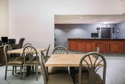 a dining room with tables and chairs and a counter at Days Inn & Suites by Wyndham Wausau in Wausau
