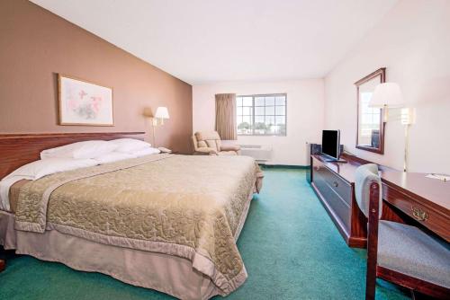 a hotel room with a large bed and a desk at Super 8 by Wyndham Richmond in Richmond