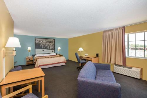 ein Hotelzimmer mit einem Bett und einem Schreibtisch in der Unterkunft Super 8 by Wyndham Clarinda in Clarinda