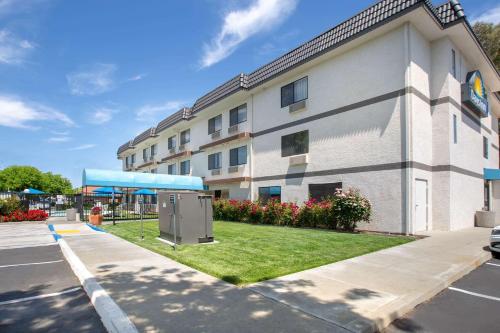 a building with a green lawn in front of it at Days Inn by Wyndham Woodland in Woodland