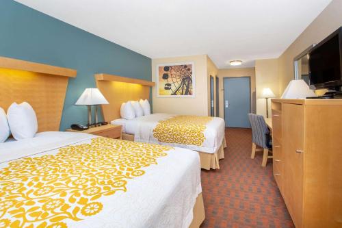 A bed or beds in a room at Days Inn by Wyndham Woodland