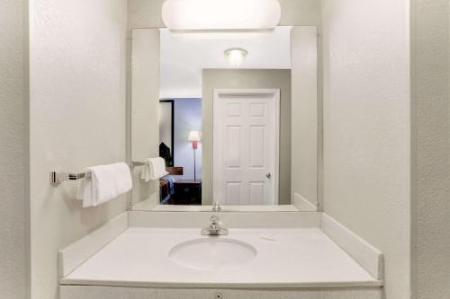 a bathroom with a sink and a mirror at Super 8 by Wyndham Booneville in Booneville
