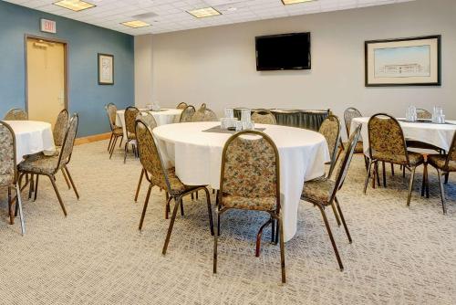 a conference room with tables and chairs and a tv at Wingate by Wyndham Fargo in Fargo
