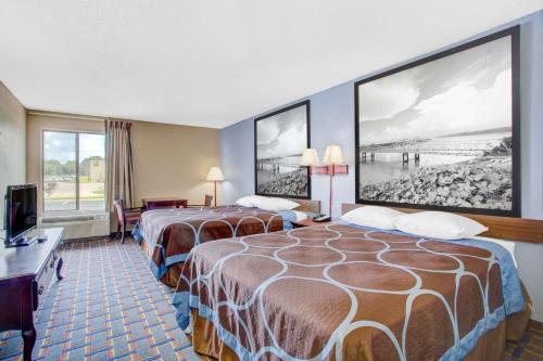 a hotel room with two beds and a television at Super 8 by Wyndham Booneville in Booneville