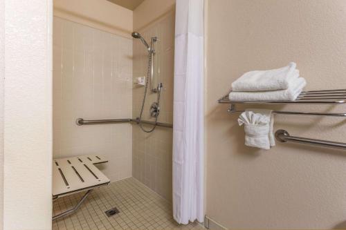 a bathroom with a shower with a bench and towels at Super 8 by Wyndham Dixon/UC Davis in Dixon