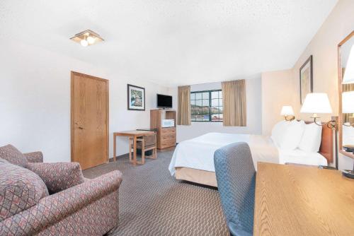 a hotel room with a bed and a couch at Days Inn by Wyndham West Rapid City in Rapid City