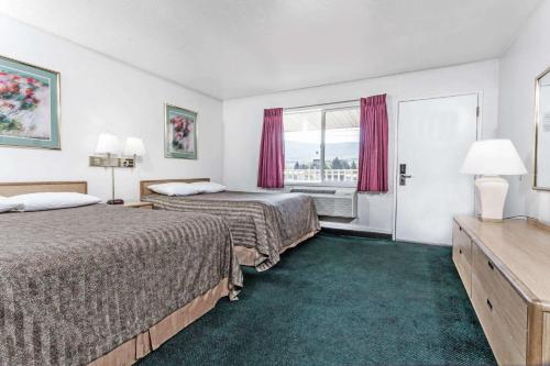 ラグランデにあるTravelodge by Wyndham La Grandeのベッド2台と窓が備わるホテルルームです。
