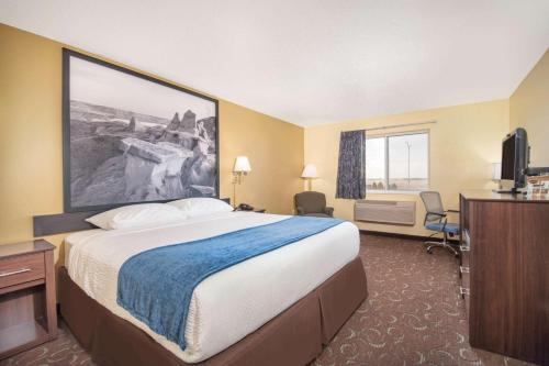 a hotel room with a large bed and a television at Four Seasons Inn in Bottineau