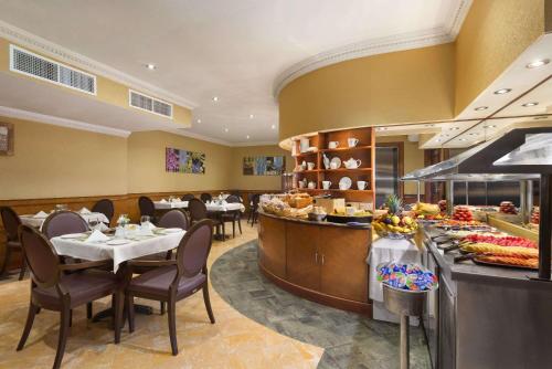 ein Restaurant mit Tischen und Stühlen und einem Buffet in der Unterkunft Howard Johnson by Wyndham Abu Dhabi Downtown in Abu Dhabi