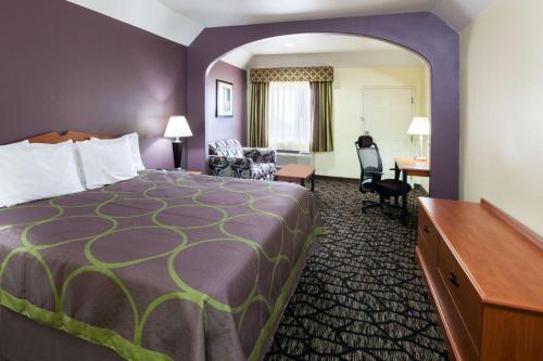 a hotel room with a bed and a desk at Super 8 by Wyndham Fairfield Tx in Fairfield