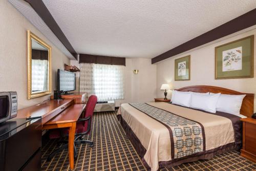 YadkinvilleにあるDays Inn by Wyndham Yadkinvilleのベッドとデスクが備わるホテルルームです。