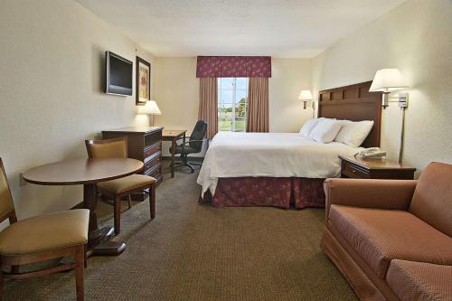 a hotel room with a bed and a table and chairs at Super 8 by Wyndham Bowling Green North in Bowling Green