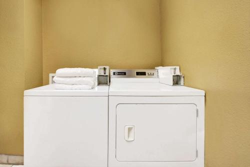 a white washer and dryer with towels on top of it at Super 8 by Wyndham Richardson Dallas in Richardson