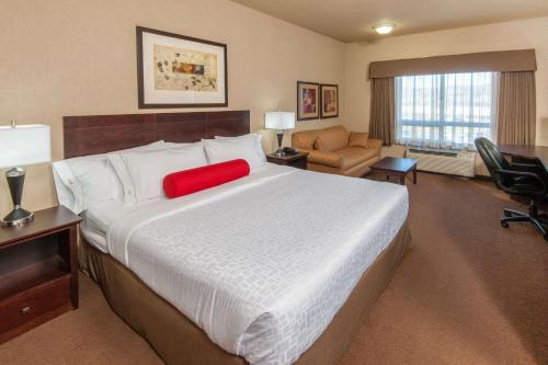 Un pat sau paturi într-o cameră la Ramada by Wyndham Drumheller Hotel & Suites