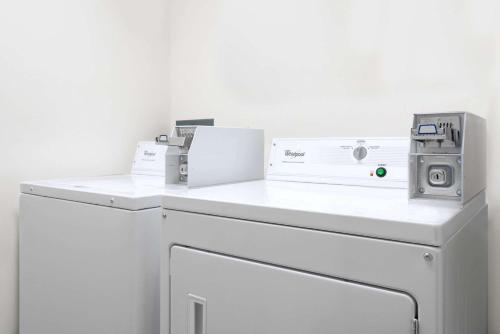 a washing machine with two machines on top of it at Baymont by Wyndham La Crosse/Onalaska in Onalaska