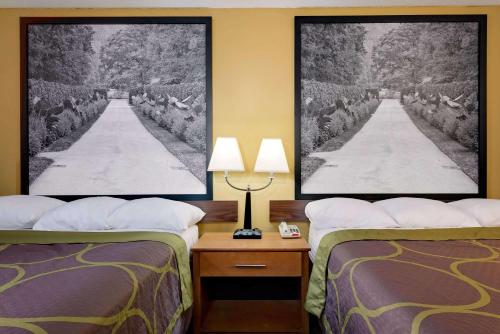 a hotel room with two beds and a table with lamps at Super 8 by Wyndham Allentown in Allentown