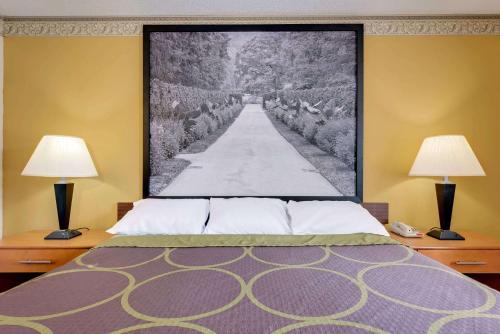 a bedroom with two lamps and a large picture on the wall at Super 8 by Wyndham Allentown in Allentown