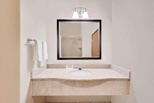 ein Bad mit einem Waschbecken und einem Spiegel in der Unterkunft Super 8 by Wyndham Odessa TX in Odessa