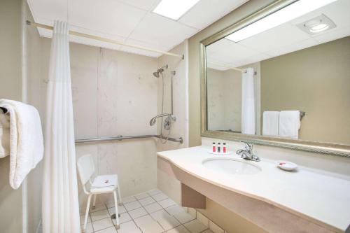 a bathroom with a sink and a shower and a mirror at Baymont by Wyndham Hays in Hays