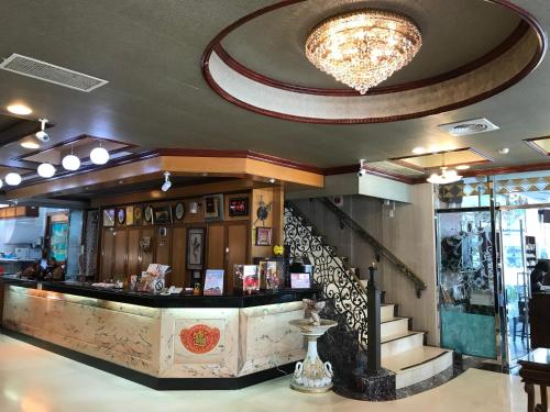 a restaurant with a counter and a chandelier at Sunrise Hotel in Tainan