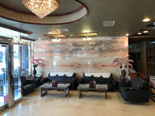 a lobby with a stone wall with couches and tables at Sunrise Hotel in Tainan