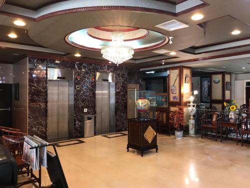 a lobby with a chandelier and a table and chairs at Sunrise Hotel in Tainan